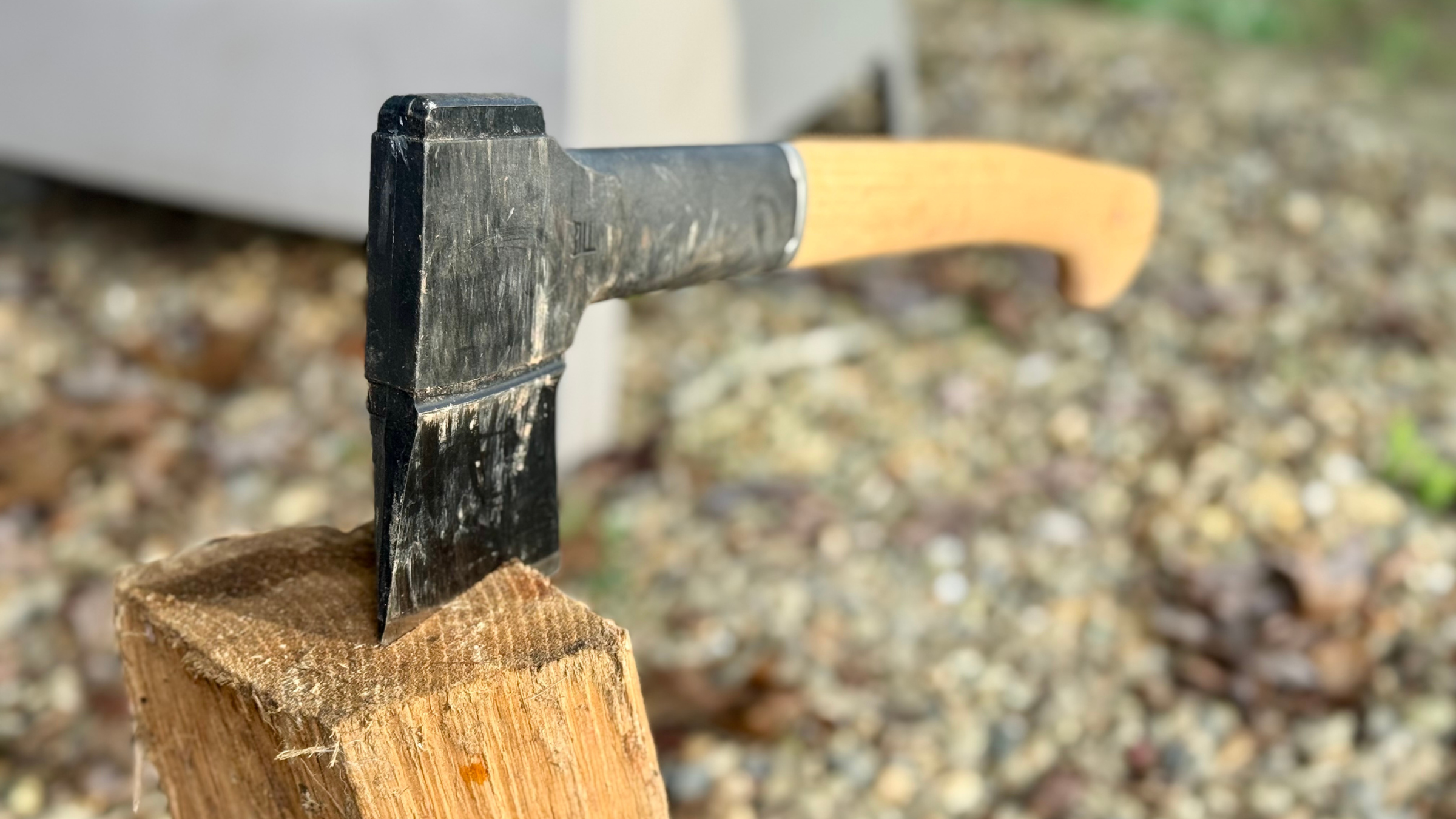 Fiskars Norden N10 Chopping Axe with wooden handle stuck in end of piece of chopped wood